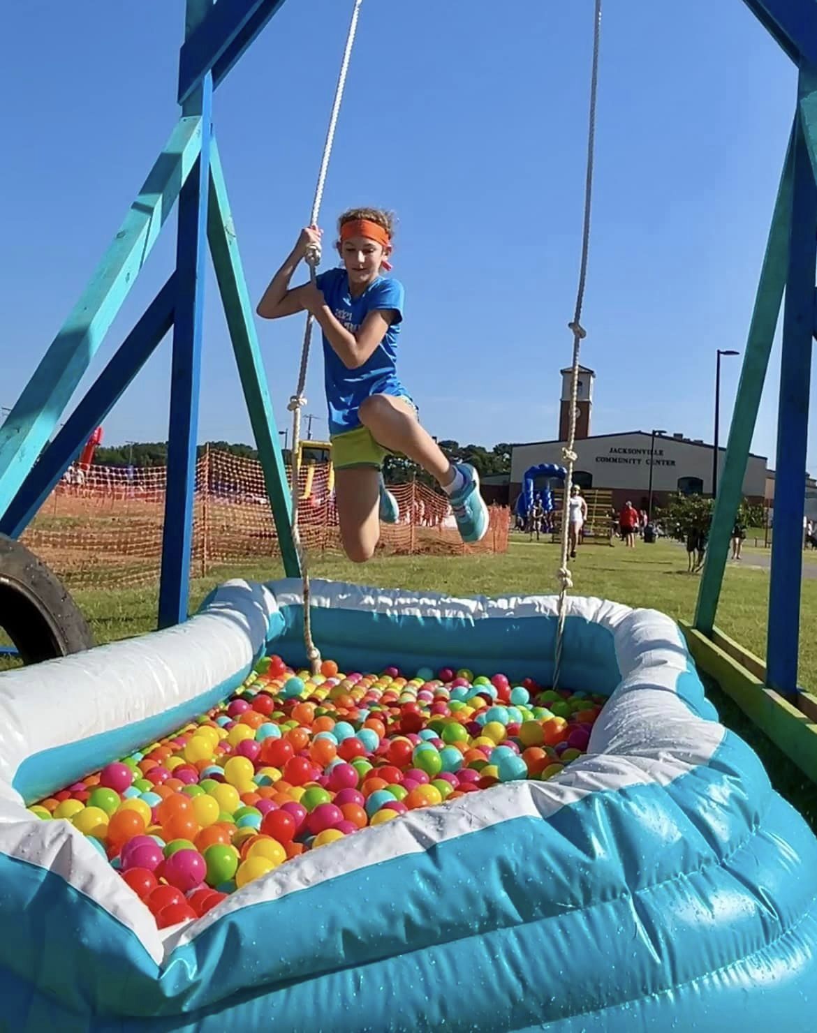 Kid swinging over ball pit